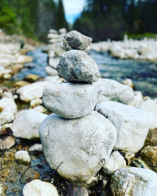 Stones piled up in front of a river - a possible metaphor for balance